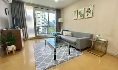 Stylish living room with modern decor and balcony view in urban apartment.