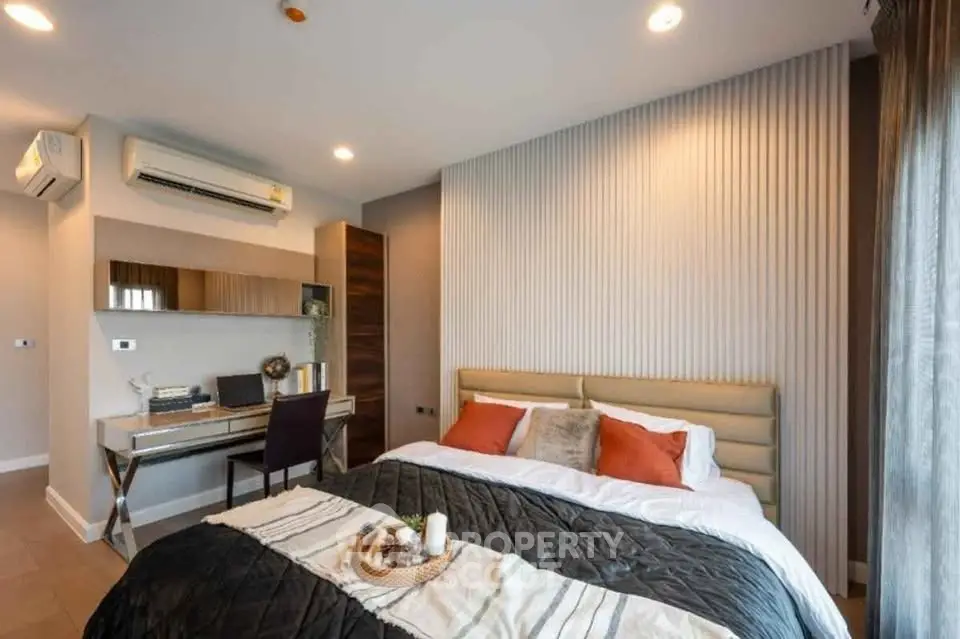 Modern bedroom with stylish decor and workspace, featuring a cozy bed and elegant lighting.