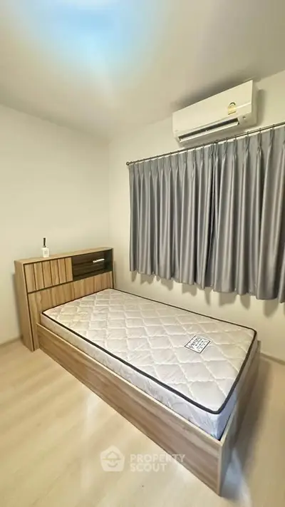 Cozy bedroom with single bed, air conditioning, and modern furnishings.
