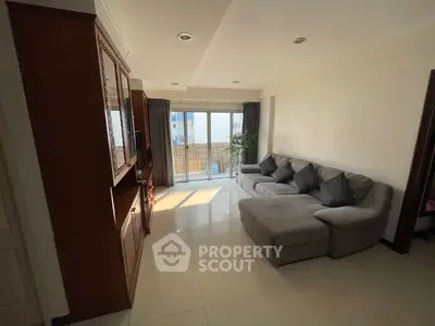 Spacious living room with modern sectional sofa and large windows offering natural light.