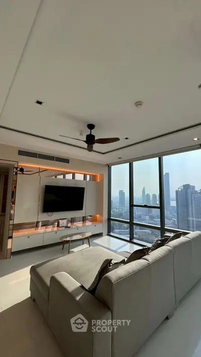 Luxurious living room with panoramic city view, modern decor, and spacious seating area.