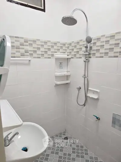 Modern bathroom with shower and tiled walls in a real estate property.