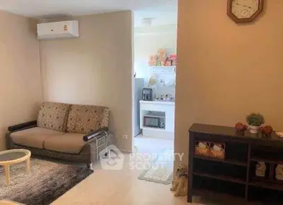 Cozy living room with modern decor and adjacent kitchen area, perfect for urban living.