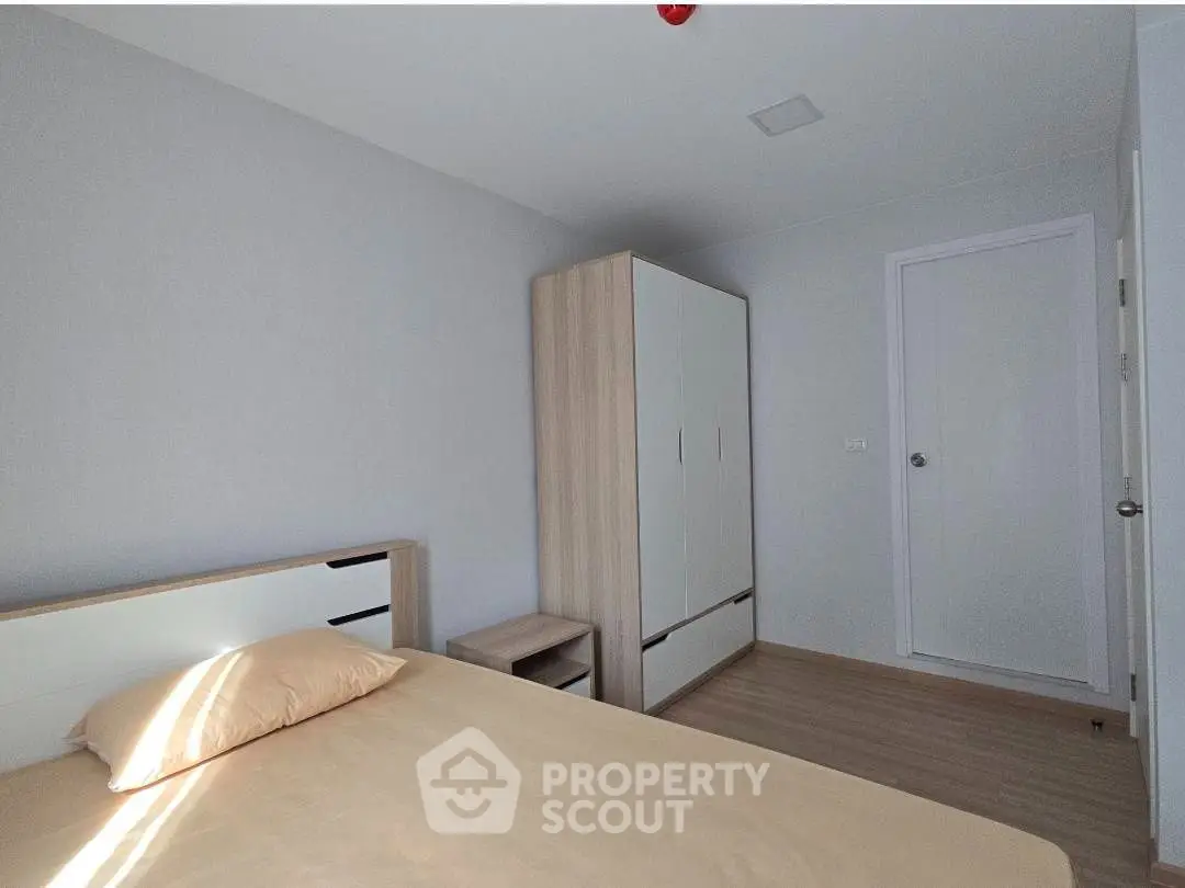 Modern minimalist bedroom with wooden wardrobe and neutral tones.