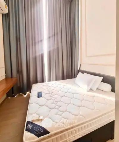 Cozy bedroom with natural light and elegant curtains, featuring a comfortable mattress and stylish decor.