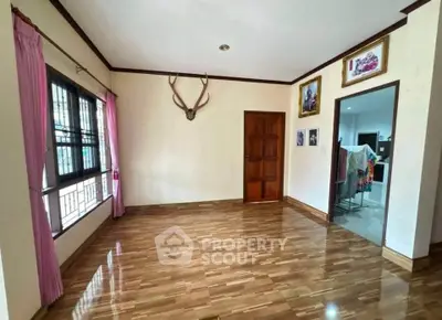 Spacious living room with wooden flooring and natural light