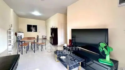 Spacious living room with modern decor and large TV, perfect for relaxation.
