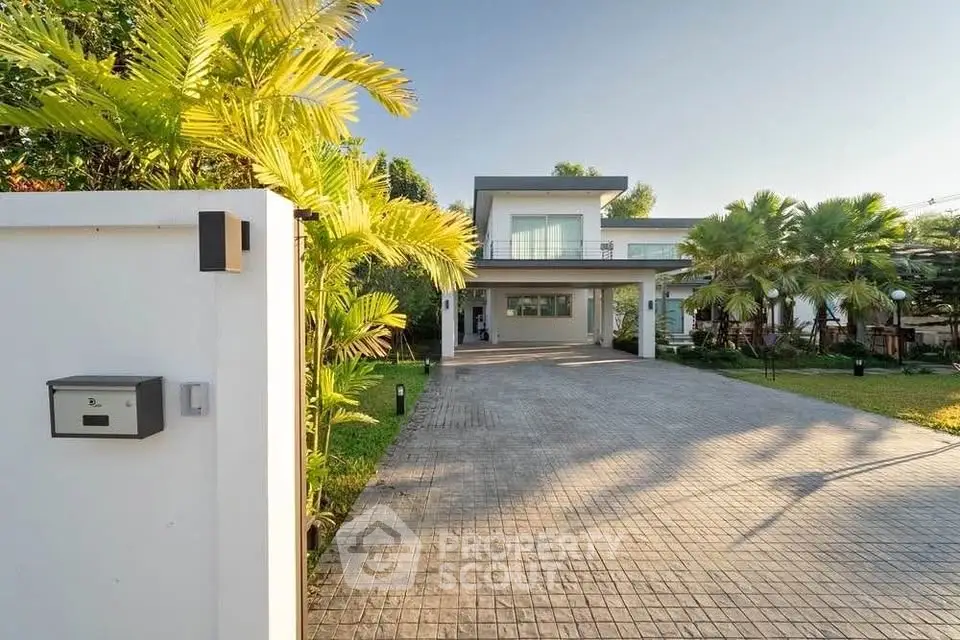 Modern luxury home with spacious driveway and lush greenery, perfect for upscale living.