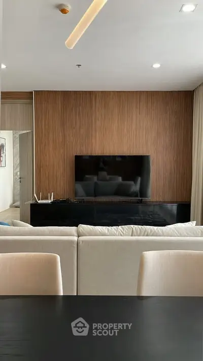 Modern living room with sleek TV setup and wooden accent wall