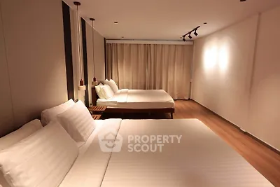Spacious modern bedroom with two large beds and elegant lighting