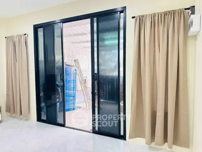 Spacious room with sliding glass doors leading to a covered outdoor area.