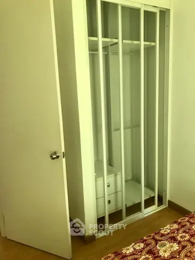 Spacious bedroom with built-in mirrored wardrobe and elegant flooring