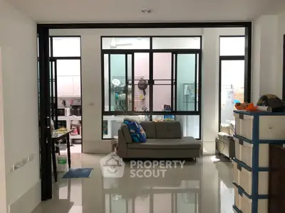 Modern living room with sleek sofa and glass partition, showcasing a stylish and functional interior design.