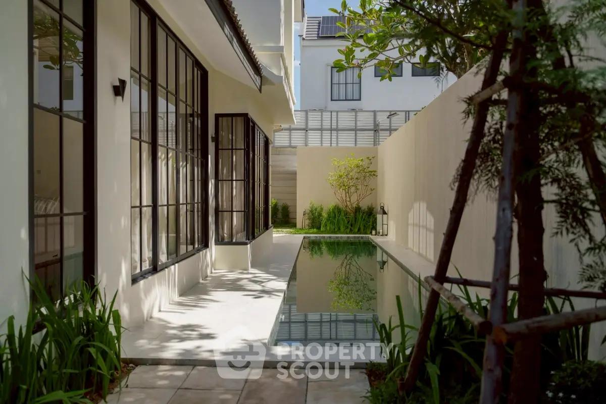Luxurious private pool with modern architecture and lush greenery in a serene residential setting.