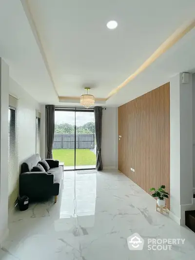 Modern living room with elegant decor and large sliding glass doors opening to a lush garden view.