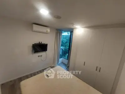 Cozy bedroom with air conditioning and balcony view, perfect for relaxation.