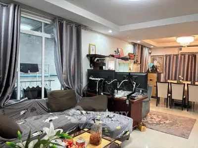 Spacious living room with modern decor and dining area, featuring elegant curtains and cozy seating.