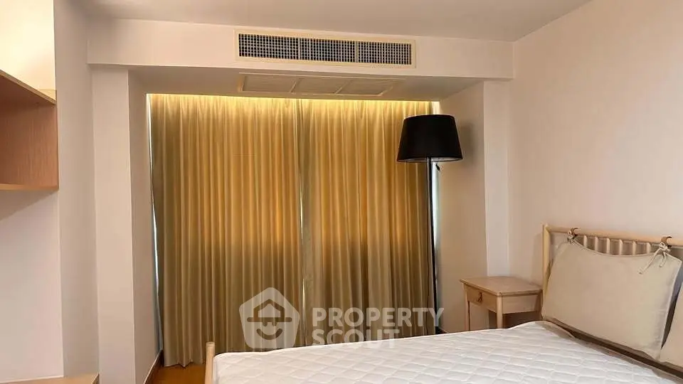 Cozy bedroom with modern lighting and elegant curtains, featuring a comfortable bed and stylish decor.