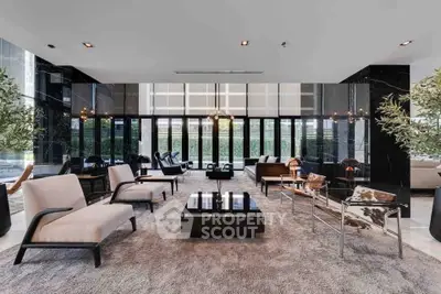 Luxurious modern living room with elegant furniture and floor-to-ceiling windows offering a stunning view.