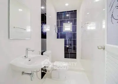 Modern bathroom with sleek white fixtures and spacious shower area