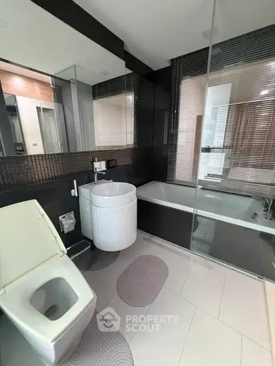 Modern bathroom with sleek design, featuring a bathtub and stylish fixtures.