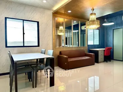 Modern living room with elegant chandelier and stylish furniture, featuring a cozy sofa and dining area.