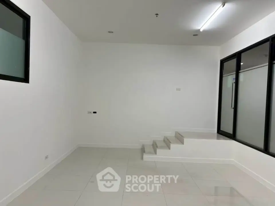 Spacious modern interior with sleek white tiles and minimalist design, perfect for customization.
