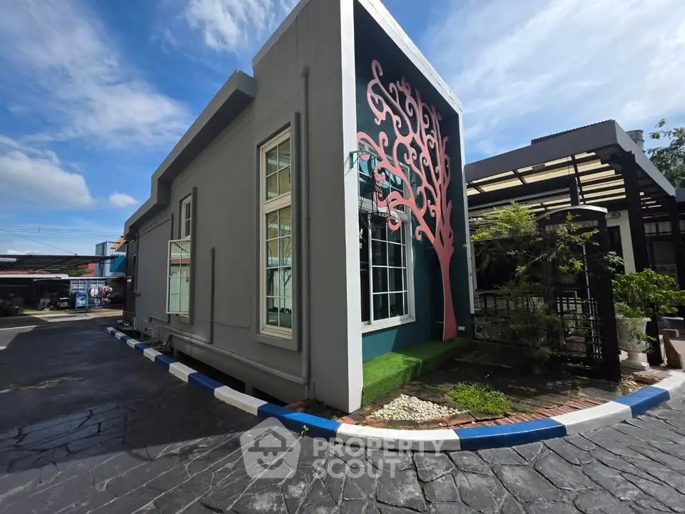 Modern building exterior with unique tree mural and spacious driveway