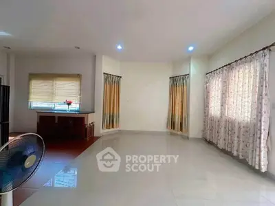 Spacious living room with large windows and elegant curtains