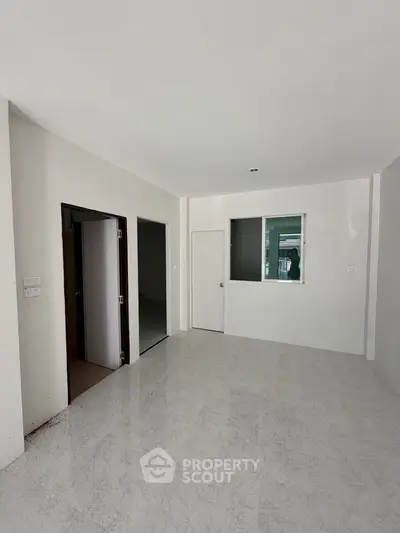 Spacious unfurnished room with marble flooring and white walls, ideal for customization.