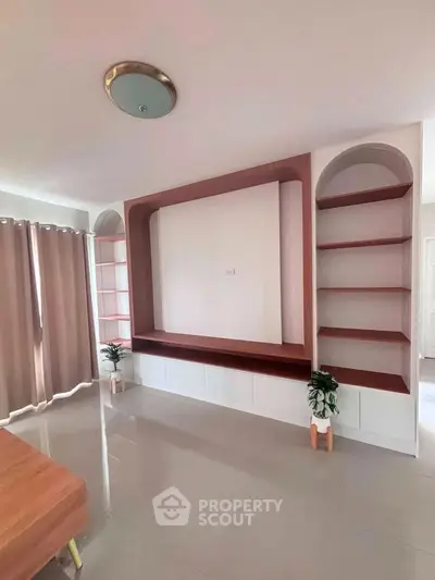Spacious living room with modern built-in shelves and elegant curtains