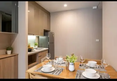 Modern kitchen with dining area, sleek cabinetry, and elegant table setting.