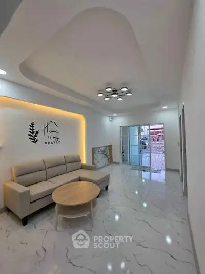 Spacious modern living room with elegant ceiling design and cozy sofa, perfect for relaxation.
