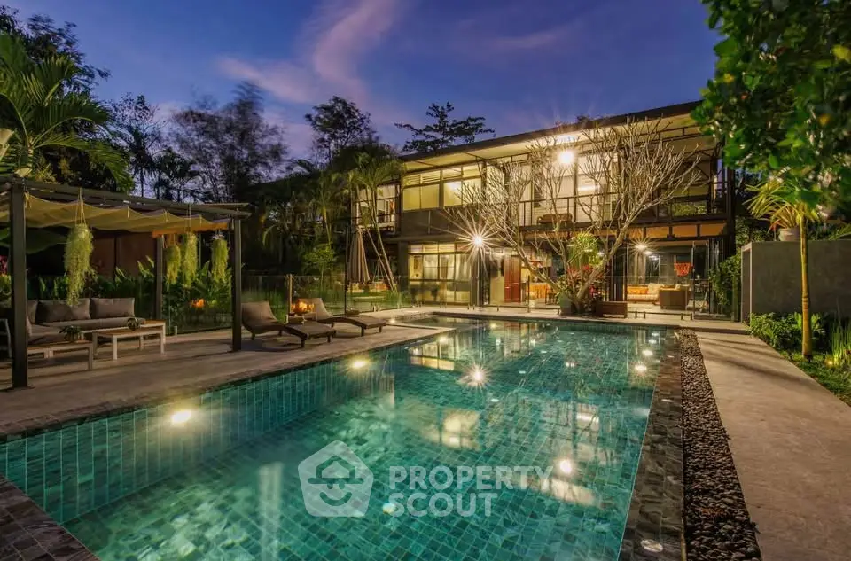 Luxurious modern villa with illuminated pool and lush garden at dusk, perfect for serene living.