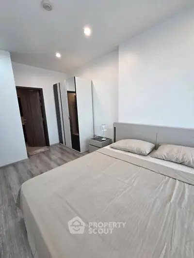 Modern bedroom with sleek design and ample storage in a contemporary apartment.
