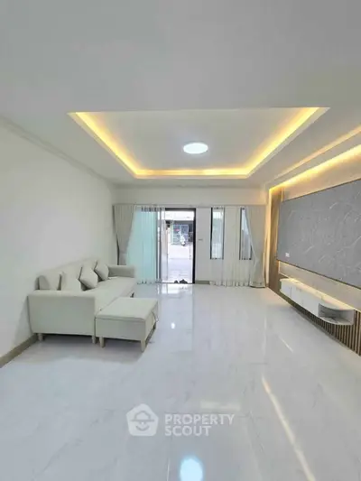 Spacious modern living room with elegant lighting and large windows.