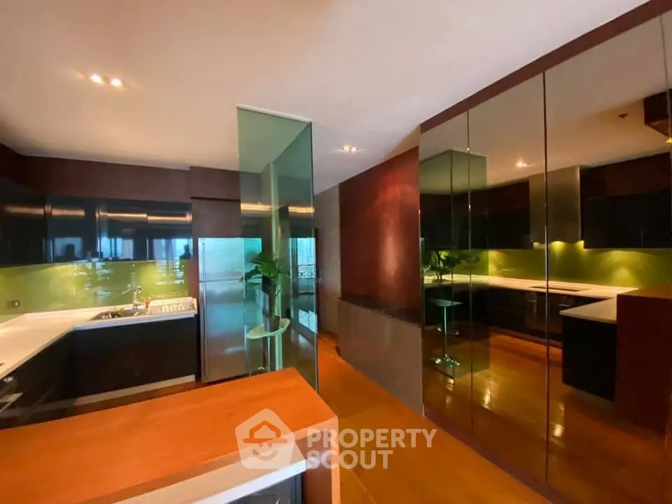 Modern kitchen with sleek design, glass partitions, and vibrant green backsplash.