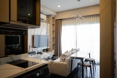 Modern living room with sleek furniture and large window offering natural light.