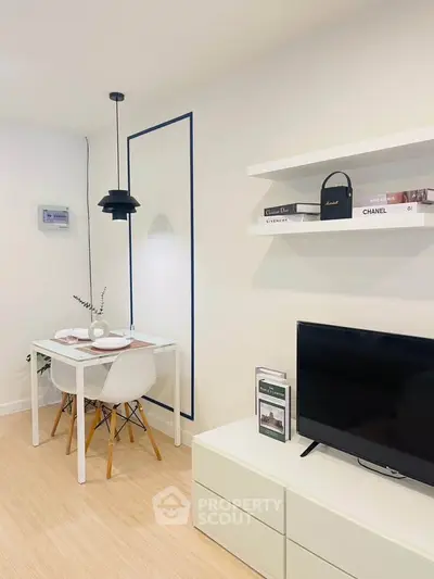 Modern living room with minimalist decor, featuring a sleek TV stand, stylish dining area, and elegant shelving.