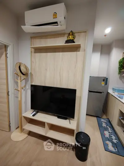 Modern living room with TV, air conditioner, and stylish decor in a cozy apartment setting.