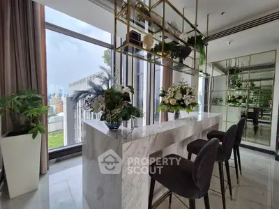 Luxurious modern living room with marble bar, elegant decor, and stunning city view.