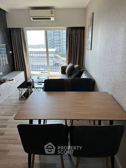 Modern living room with stylish furniture and city view from large window.