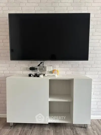 Modern living room with sleek TV setup and stylish white cabinet
