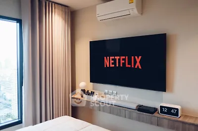 Modern bedroom with wall-mounted TV and city view window