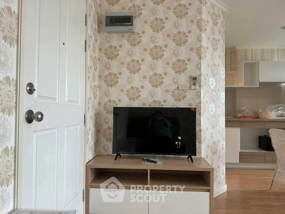 Charming living room with floral wallpaper and modern TV setup, perfect for cozy relaxation.