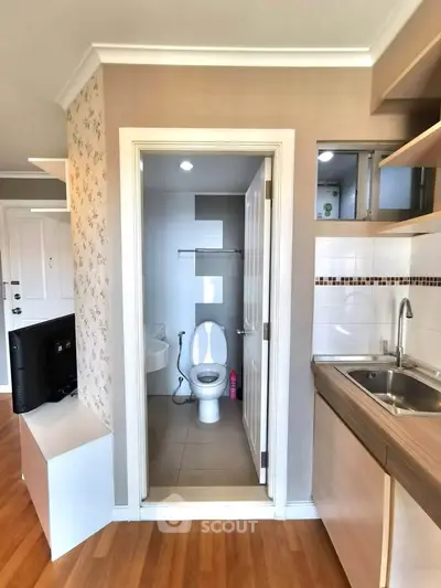 Compact apartment interior with open kitchen and small bathroom