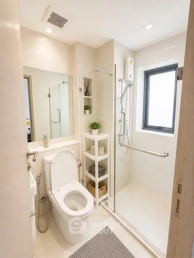 Modern bathroom with sleek shower, white fixtures, and natural light from window.