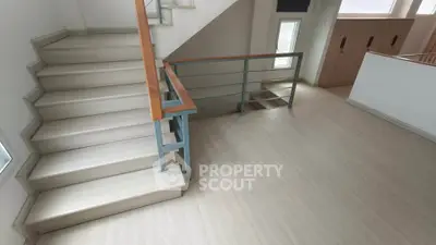 Spacious modern staircase with sleek wooden railings and bright natural lighting