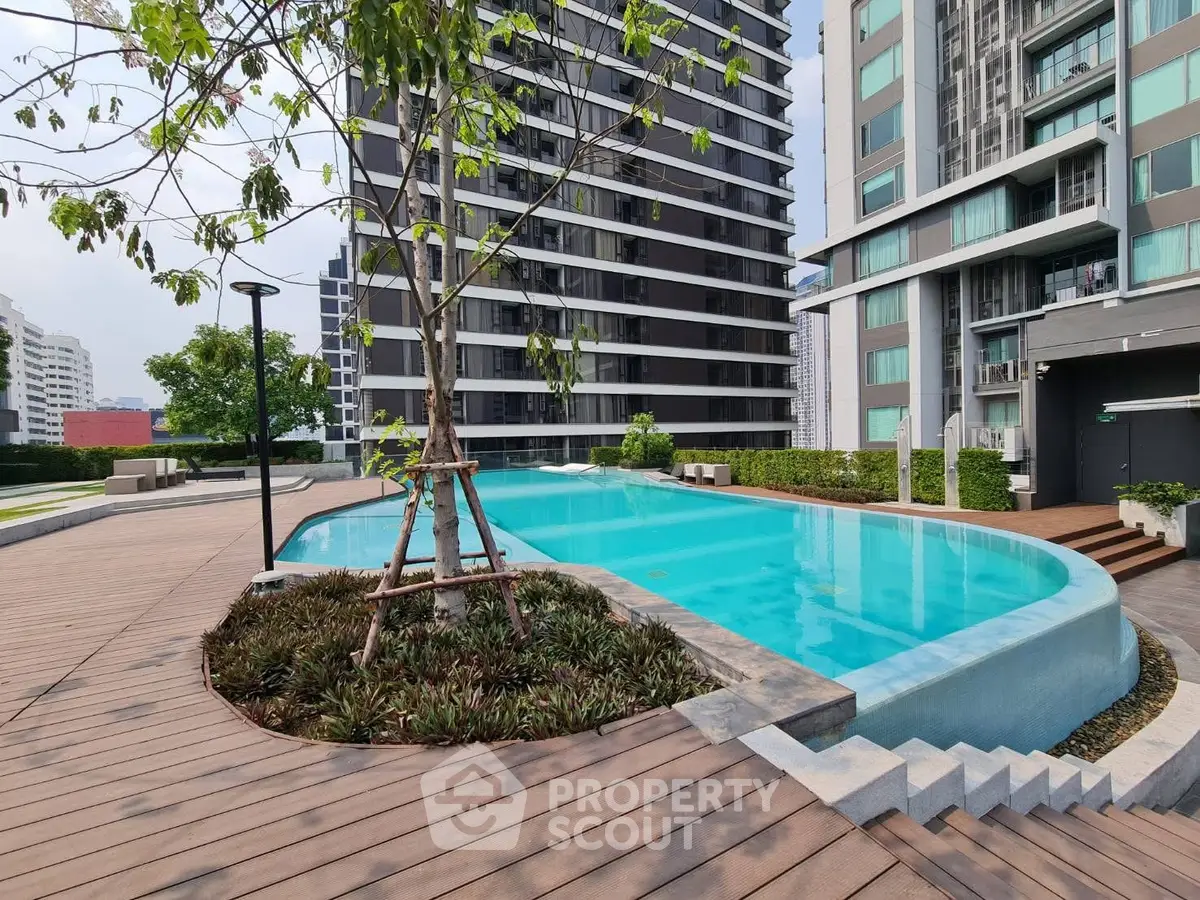 Luxurious condominium with modern pool and lush landscaping in urban setting.