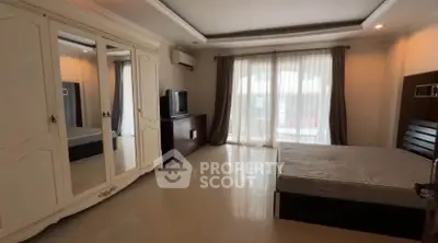 Spacious bedroom with large wardrobe and natural light from balcony access.